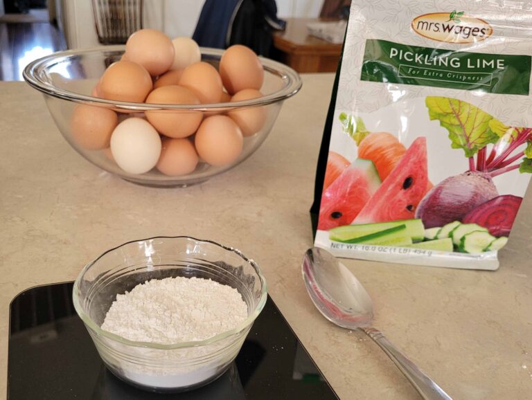 bowl of eggs with bag and dish of pickling lime on countertop