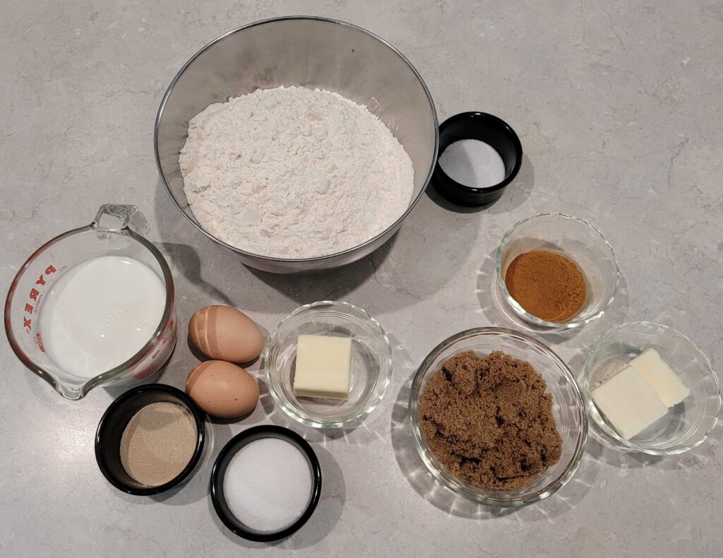 Cinnamon roll ingredients in various bowls and dishes