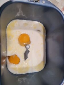 Milk, eggs and butter in a bread machine bread pan